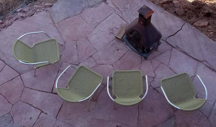 Contemporary seating overlooking the metal fire pit sitting on red sandstone
